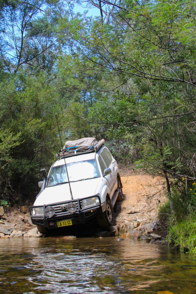 One of many crooked river crossings with Finn at attention and Miranda behind the wheel!